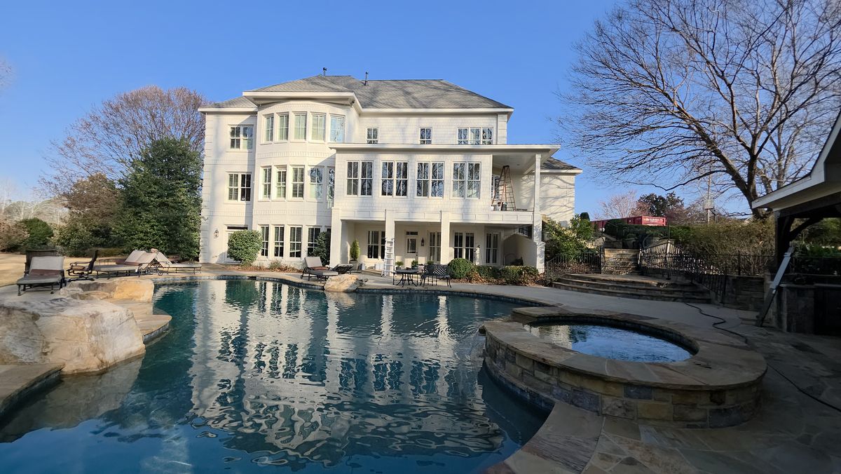 White two-story home with a pool terrace — exterior project by Diaz Siding