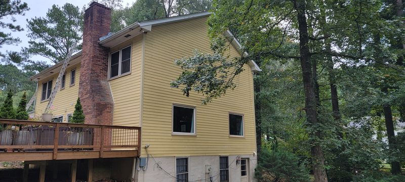 Yellow house with existing siding, deck and chimney before Diaz work began